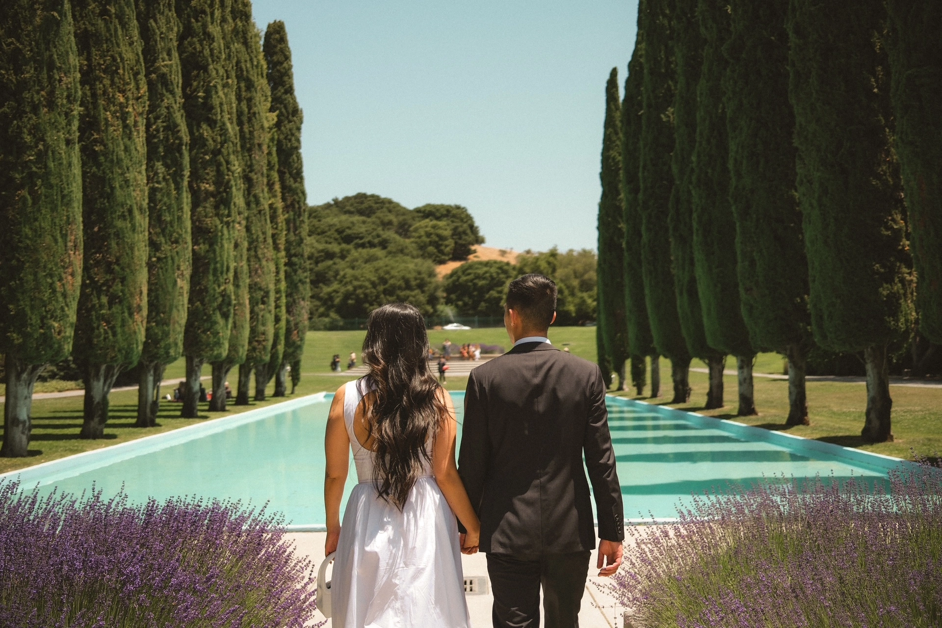 Couple by pool with cypress trees