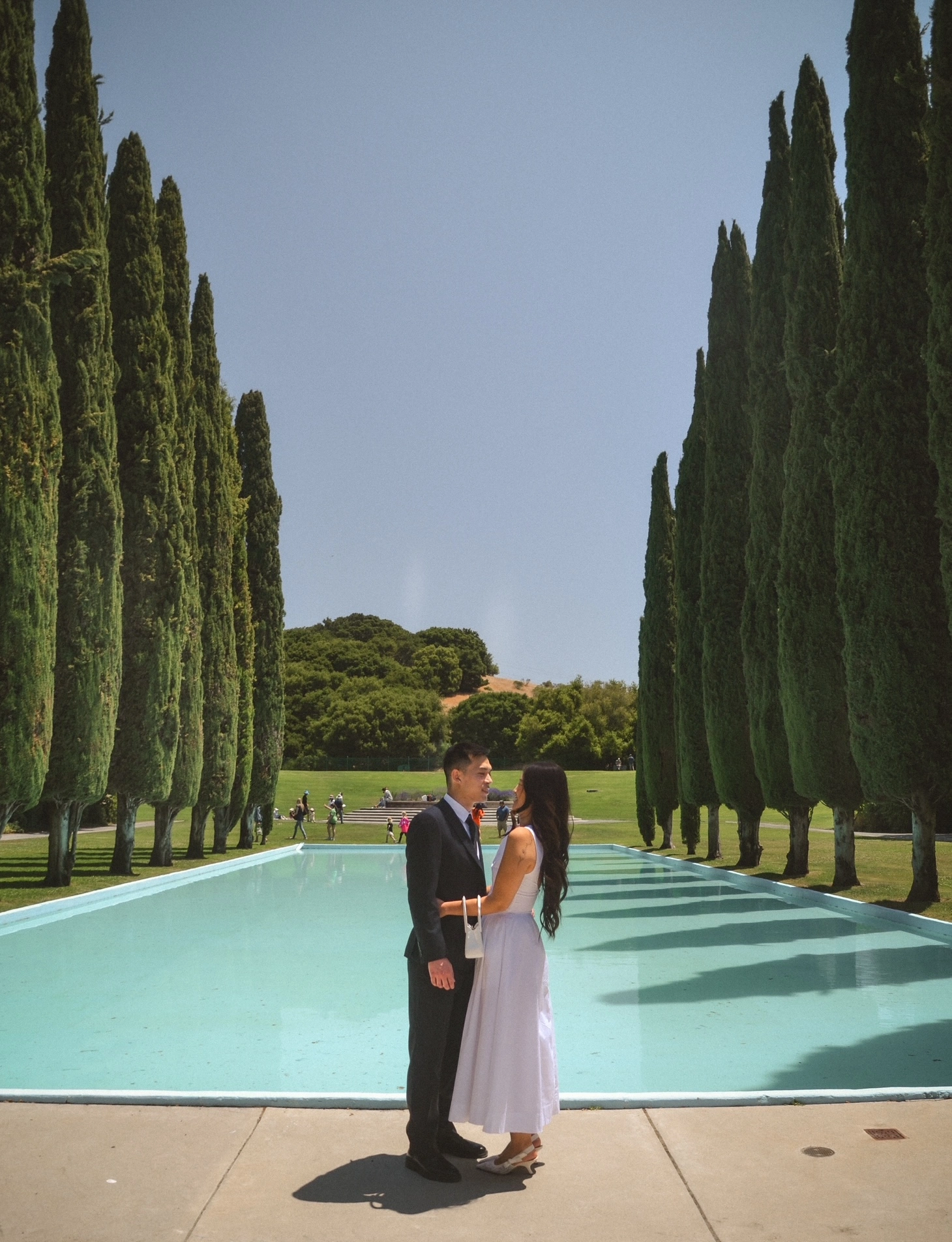 Couple by pool and cypress trees